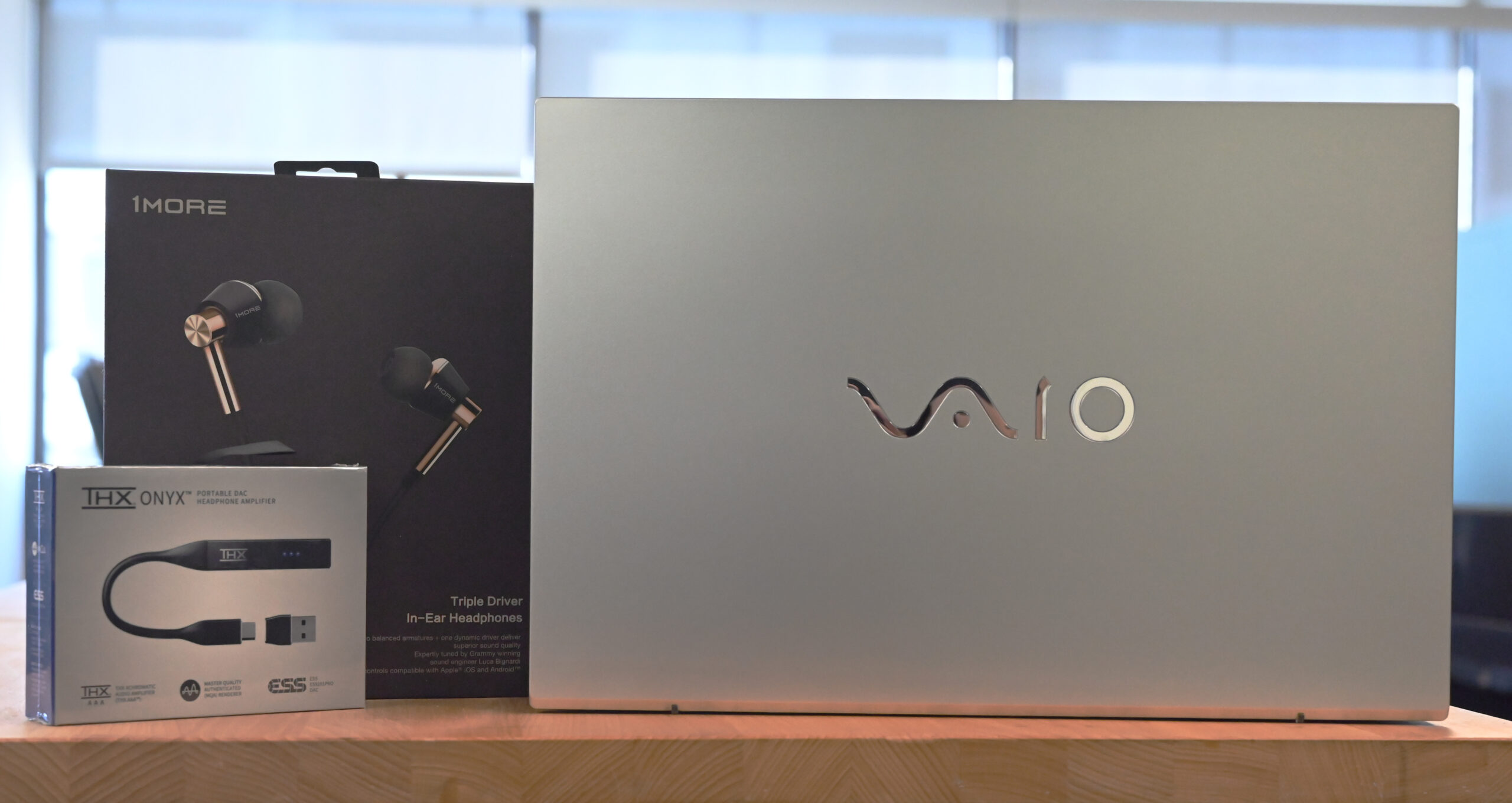 1MORE headphones, THX onyx and VAIO laptop sitting on a table